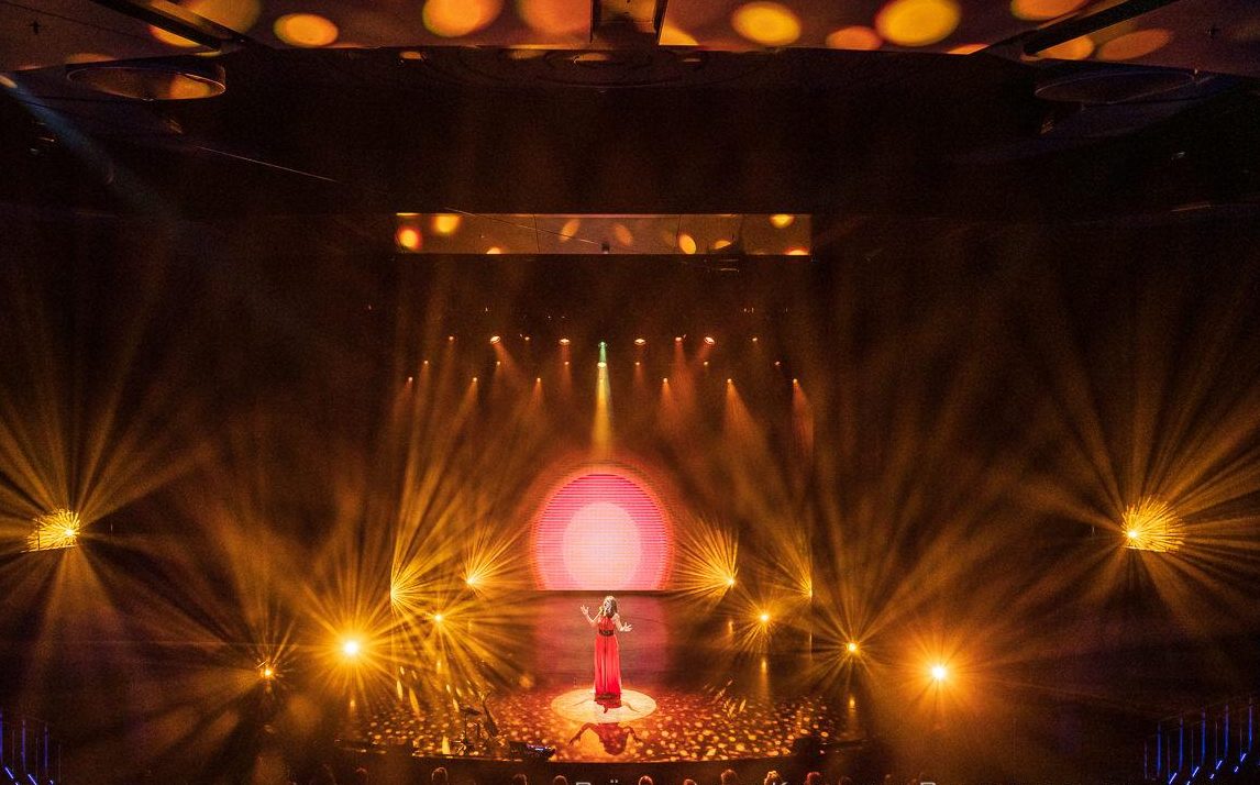 Sängerin auf großer Bühne mit Lightshow