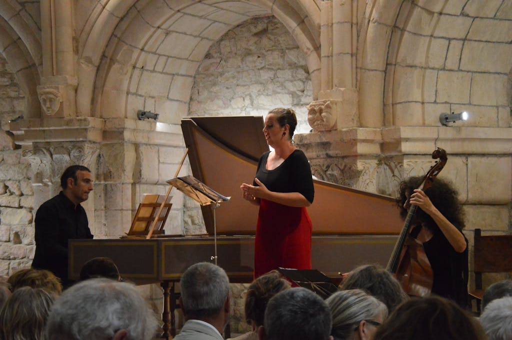 A live classical music performance with singer, pianist, and cellist in a historic venue.