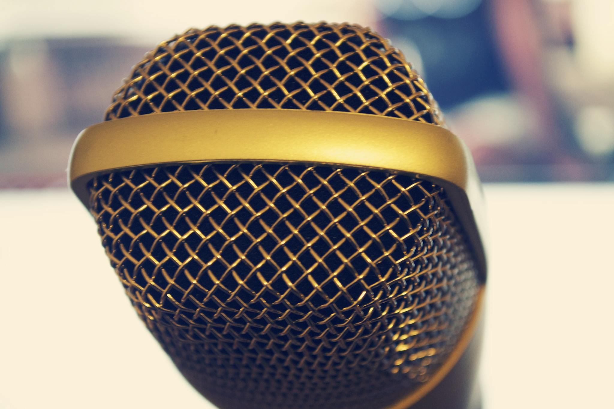 Elegant close-up of a gold microphone, perfect for audio and music themes.